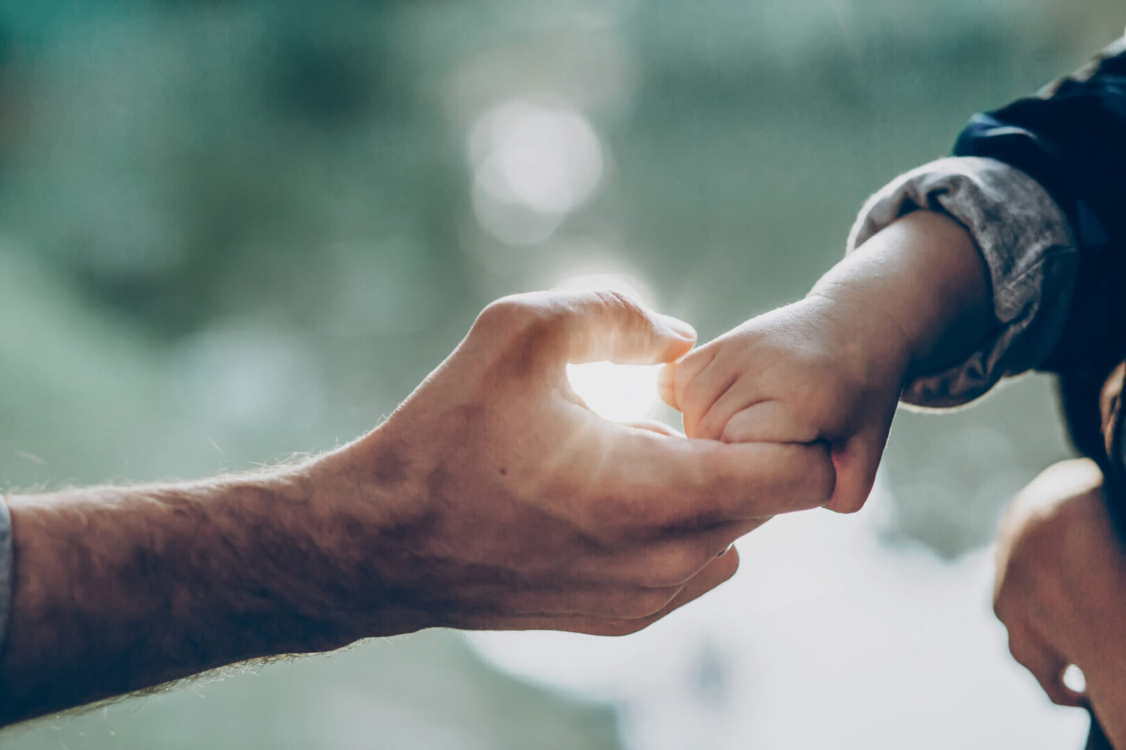 A man and woman holding hands in the sunlight.