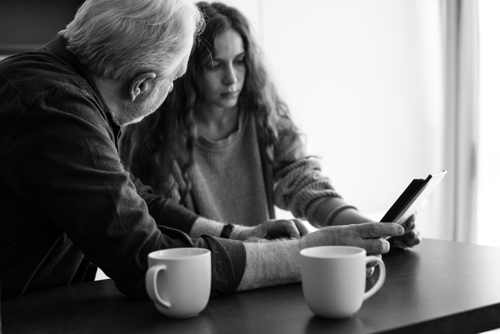 A man and woman looking at a tablet.